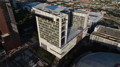 Aerial-view-around-the-sunlit-Hilton-Americas-Houston-hotel,-sunrise-in-Texas,-USA