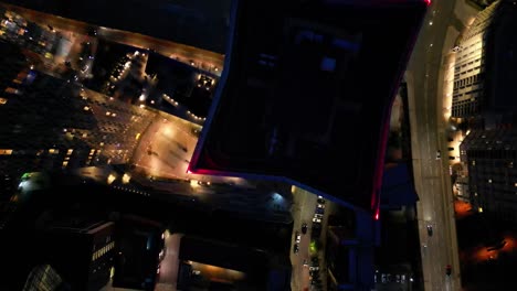 Luftdrohnen-Nachtflug-über-Den-Elizabeth-Towers-Im-Stadtzentrum-Von-Manchester,-Der-Einen-Blick-Aus-Der-Vogelperspektive-Auf-Das-Dach-Und-Den-Fließenden-Verkehr-Darunter-Bietet