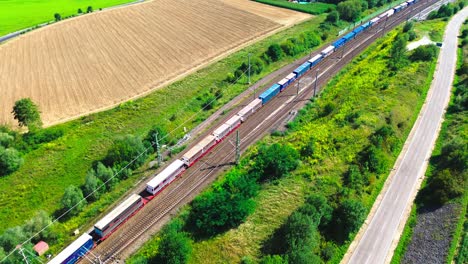 aerial-drone-freight-train-along-highway-4k