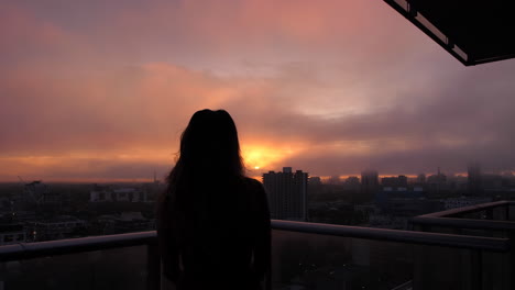 A-silhouetted-woman-overlooking-the-city-at-golden-hour
