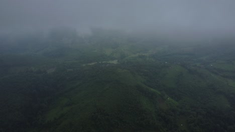 Blanket-of-dense-white-fog-almost-covers-green-landscape-below