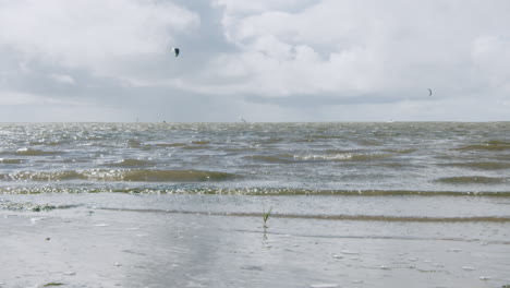 Slowmotion-shot-of-small-waves-hitting-the-shore-at-the-beach-of-Sankt-Peter-Ording