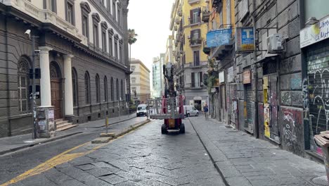 Scene-of-a-semi-auto-crane-truck-lifting-a-small-wagon-and-street-view-in-Naples,-Italy
