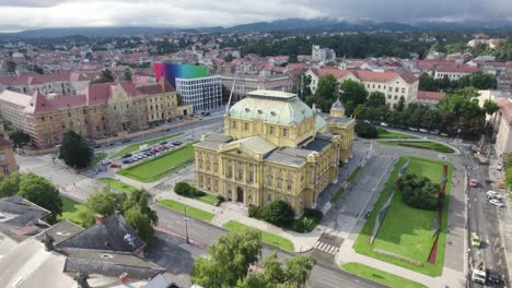Aerial-view-circling-the-Croatian-national-theatre,-Zagreb-scenic-urban-public-garden-town-square