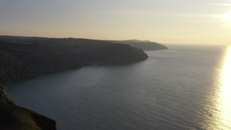 Drone-shot-moving-left-to-right-while-looking-at-Lynton-and-Lynmouth-on-the-North-Devon-coastline-at-sunset-in-the-UK