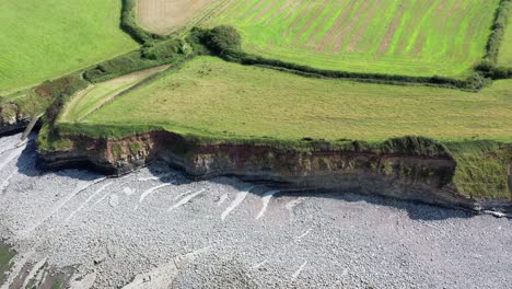 Drone-shot-while-moving-left-to-right-over-Kilve-beach-and-its-sea-cliffs-in-North-Devon,-UK