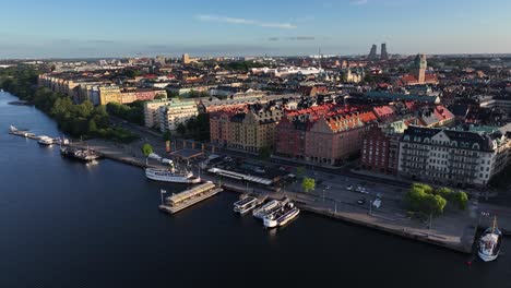 Beautiful-aerial-view-of-historic-street-and-promenade-on-riverfront,-reveal-of-Stockholm-cityscape