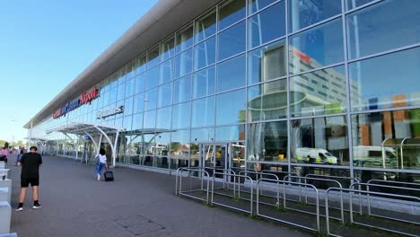 Reflection-of-Hampton,-Hilton-hotel-in-window-panning-across-Liverpool-John-Lennon-airport-departure-terminal