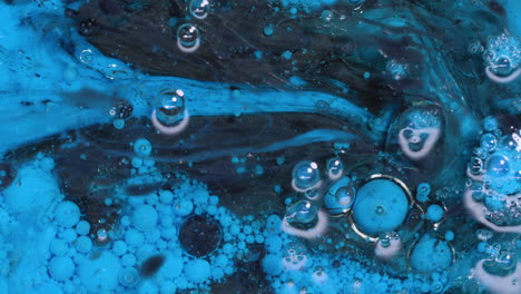 Abstract-art-background-of-swirling-blue-and-black-paint-with-bubbles-reacting-and-swirling