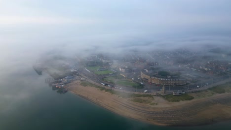 Misty-headland-town-approach-at-height-on-foggy-summer-morning-at-Fleetwood-,-Lancashire,-UK