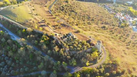 Drone-shot-of-a-medieval-age-tower-and-ruins-on-a-hill-in-Alentejo,-Portugal