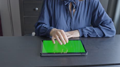 Woman-tapping-on-tablet-and-zooms-in,-green-screen-closeup
