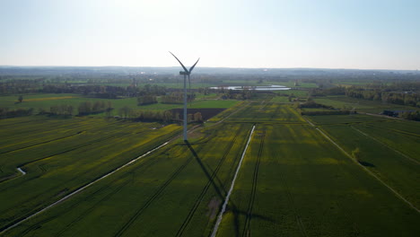 High-Up-Aerial-view-of-Single-Wind-Turbine-Roratng-Blands-Standing-in-Agricultural-Crop-Field
