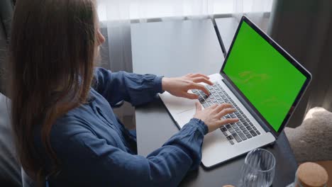 Primer-Plano-De-Una-Mujer-En-La-Oficina-Escribiendo-En-Una-Computadora-Portátil-Con-Pantalla-Verde