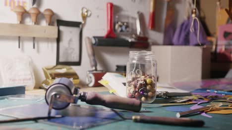 Slow-motion-dolly-shot-of-a-messy-artist-desk