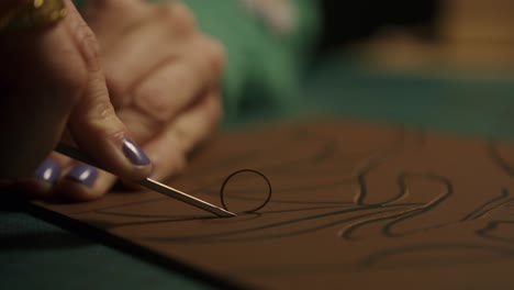 Artist-cutting-leather-with-precision-tool