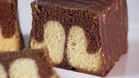 A-Reveal-Shot-Of-A-Baked-Marble-Cake-Loaf-With-Chocolate-Icing-And-A-Few-Slices