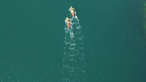 Aerial-Shot-Of-Two-People-On-Their-Surfboard-At-The-Sea-In-Aldan,-Spain