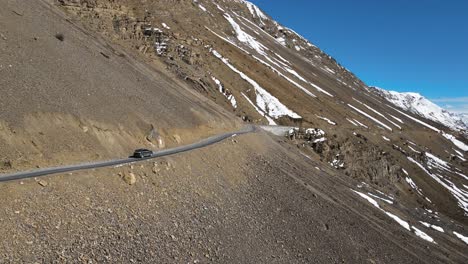 Antena-Siguiendo-Un-Jeep-Todoterreno-Conduciendo-En-Kaza-En-El-Valle-De-Spiti-En-El-Himalaya,-India