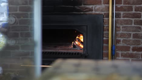 Holzverbrennung-Im-Inneren-Eines-Traditionellen-Pizzaofens,-Langer-Küchen-Shot-Rack-Fokus
