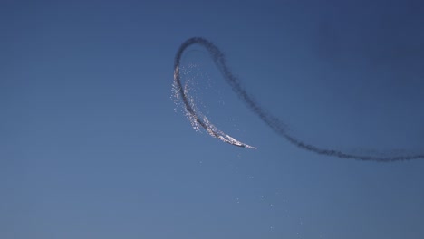 Tracking-shot-of-a-pyrotechnic-aircraft-letting-off-fireworks-during-its-display
