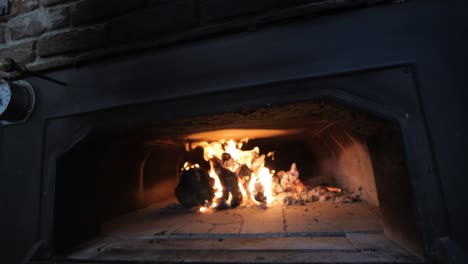 Dolly-Shot-of-Wood-Ablaze-Inside-Traditional-Wood-Fire-Pizza-Oven