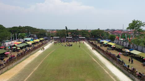 Beautiful-drone-shot-for-the-Karapan-Sapi-final-held-annually-on-Madura-Island-at-Pamekasan-Stadium,-Madura,-Indonesia