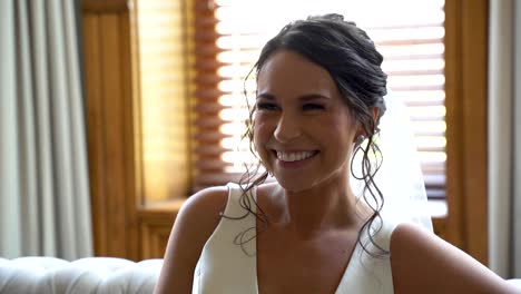 Gorgeous-brunette-smiling-on-her-wedding-day-in-a-bright-room