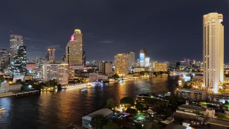 Time-lapse-shot-of-cruising-ships-on-River-Chao-Phraya-in-Bangkok-with-the-skyline-at-night