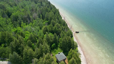 Aerial-view-of-forested-house-and-coastline,-Lake-Huron,-Michigan