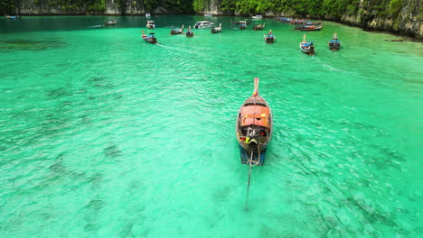 Wooden-long-tail-watercraft-sailing-turquoise-Thai-waters-off-Phi-Phi-island