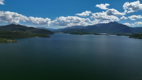 Aerial-cinematic-drone-Breckenridge-ski-resort-mountain-wide-motorboats-sailing-Lake-Dillon-Colorado-9-mile-range-summer-blue-sky-clouds-daytime-Frisco-Silverthorne-Reservoir-backward-motion