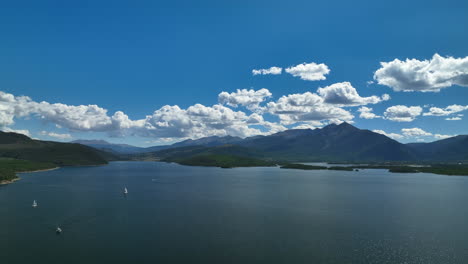 Aerial-cinematic-drone-Breckenridge-ski-resort-mountain-wide-motorboats-sailing-Lake-Dillon-Colorado-9-mile-range-summer-blue-sky-beautiful-daytime-Frisco-Silverthorne-Reservoir-forward-pan-up-motion