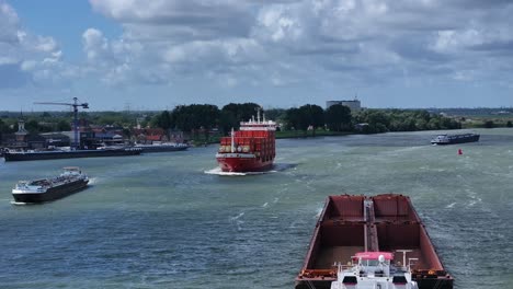 moving-empty-garbage-scow-and-cargo-ship-on-the-river-in-Zwijndrecht,-aerial-tracking