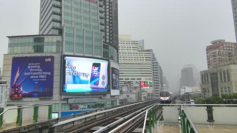 Asoke-BTS-Train-Station-in-the-Monsoon-Rains-with-a-Train-Arriving