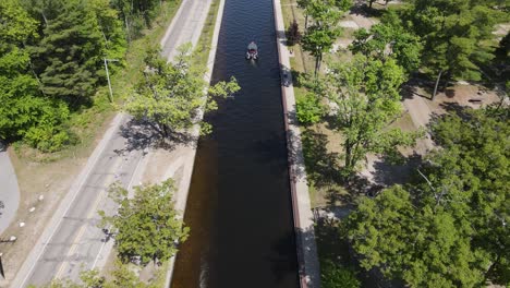 Narrow-canal-for-small-boats-to-hop-lakes-in-Michigan,-aerial-view