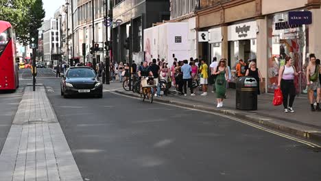 Pedestrians-and-a-car-on-Oxford-Street,-London,-United-Kingdom