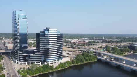 Glass-skyscraper-office-and-car-bridge-in-Grand-Rapids-town,-aerial-view