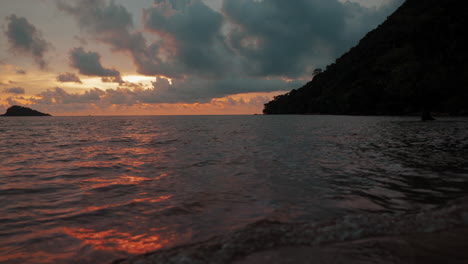 Sanfte-Meereswellen-Streicheln-Den-Einsamen-Strand-In-Koh-Chang,-Thailand,-Während-Der-Himmel-In-Den-Warmen-Farbtönen-Eines-Atemberaubenden-Sonnenuntergangs-Erstrahlt-–-Eine-Lebendige-Leinwand-Aus-Gelb,-Orange-Und-Rot