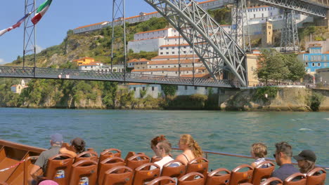 Turistas-En-Paseo-En-Barco-Por-El-Duero-Con-El-Famoso-Puente-Dom-Luís-I-Al-Fondo