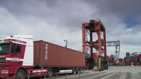 Enorme-Grúa-Portuaria-En-Funcionamiento-Descarga-Camiones-Contenedores,-Concepto-De-Negocio-Global