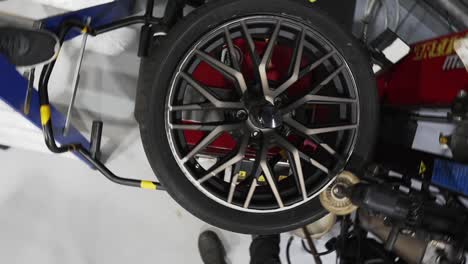 Automatic-car-wheel-cleaning-service-at-the-car-repair-shop,-360-spinning