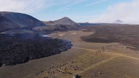 Large-group-of-tourists-standing-near-active-lava-field-in-Iceland