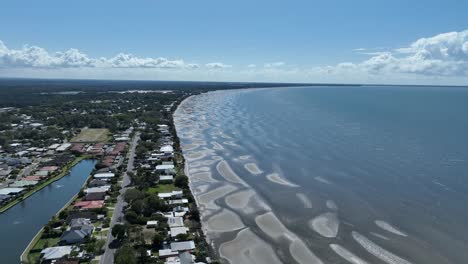 Aerial-drone-shot-above-Beachmere-beach-and-sand-banks,-Boats-in-river-opening-to-the-Ocean-Moreton-Bay