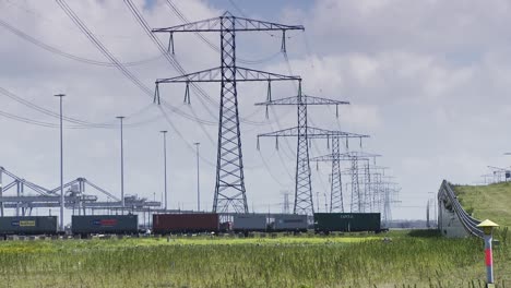 Container-lorry-in-panoramic-shipping-harbor-under-huge-electric-power-poles