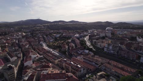Drone-flyover-Historic-Plasencia-townscape-in-Spain,-Mountain-range-in-distance