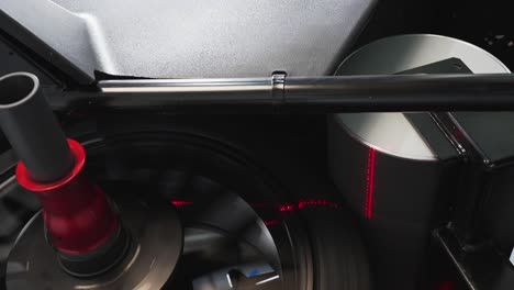 Car-technician-using-auto-wheel-balancer-machine-to-repair-wheel,-Closeup