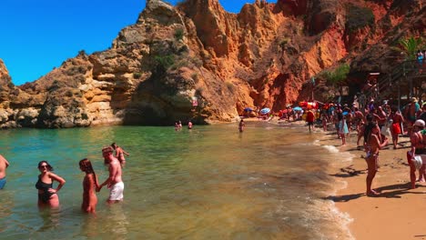 Residents-and-tourists-basking-in-the-summer-sun-at-Praia-do-Camilo,-a-picturesque-beach-in-Algarve,-Lagos,-Portugal