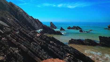 Coastline-of-rock-formation,-clear-ocean-water-and-blue-sky-in-the-Algarve