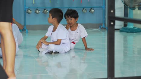 Dos-Niños-Asiáticos-Sentados-En-El-Suelo-En-La-Guardería,-Participando-En-Actividades-Lúdicas-Y-Educativas